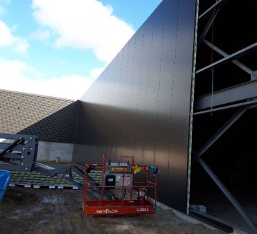 a picture of a construction site with a building being assembled with Structural Panels Isowall panels
