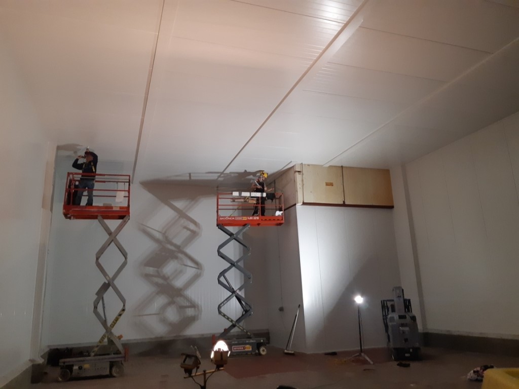 Two construction workers installing Isowall insulated wall panels