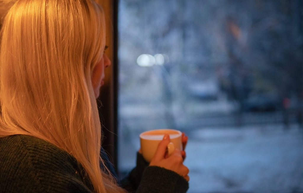 Woman looking outside at a cold winter day