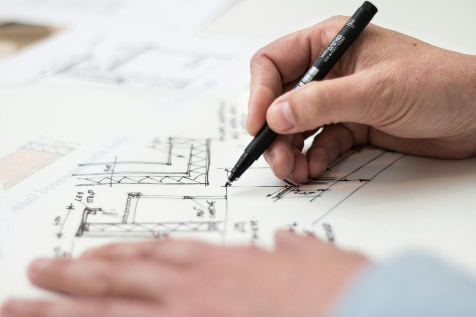 Person drawing a plan for a construction project