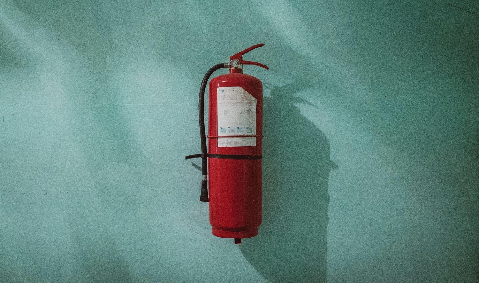 Fire extinguisher on a light green wall
