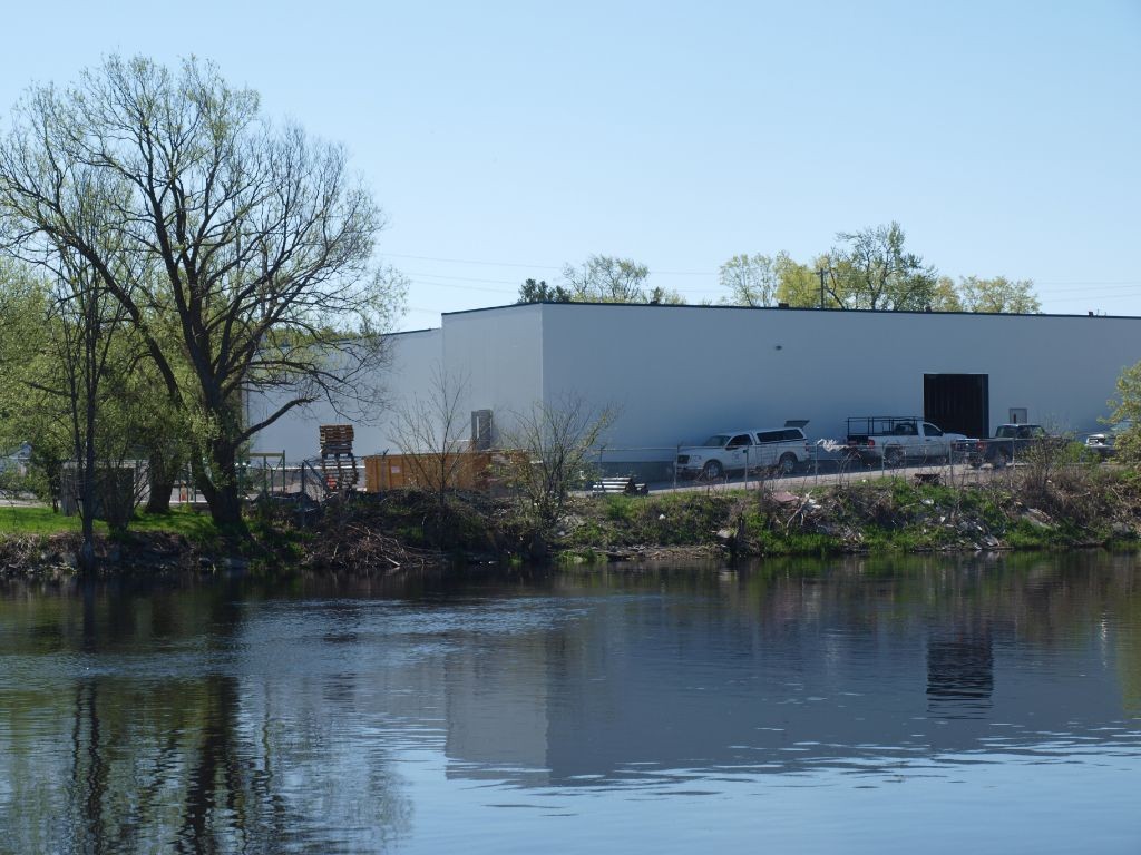 Hot tub warehouse built with insulated panels on a river with trees and greenery