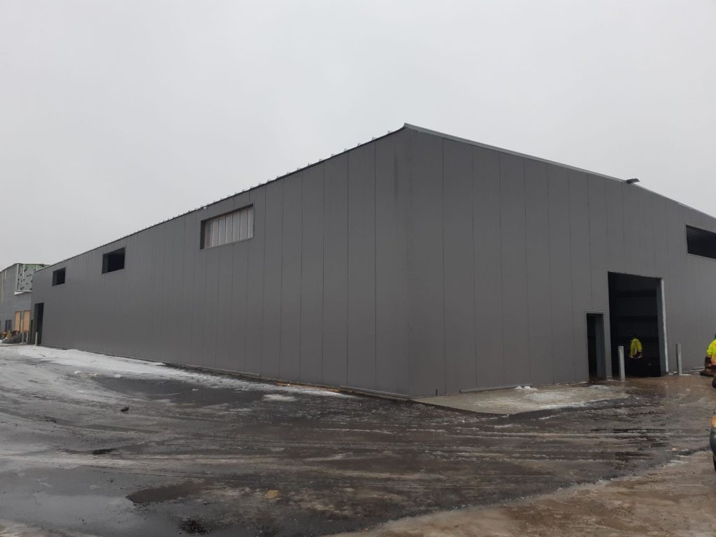 Large car dealership being constructed with insulated panels in winter